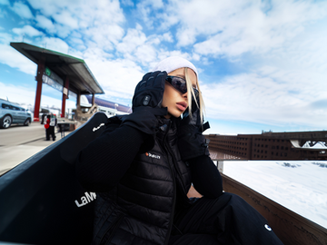 Woman wearing a GOKOZY heated vest on a snowy mountain.